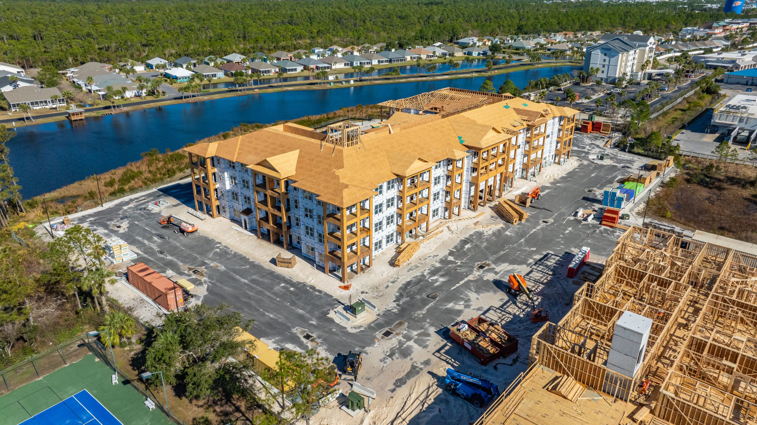 Aerial progress documentation of a four-storey multifamily building under construction — construction drone services Pensacola